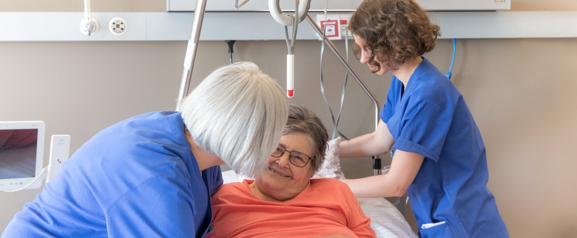 Zwei Pflegefachfrauen am Bett einer Patientin.
