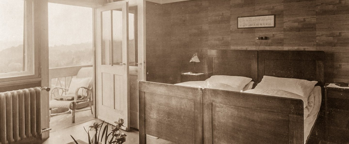 Historisches Bild eines Krankenzimmers mit Doppelbett und Balkon.